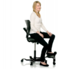 Side view of employee sitting in HAG Capisco saddle seat with step