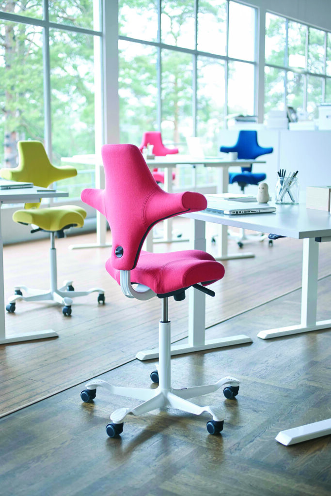 hag capisco office chairs in bright colors in open office setting with large windows